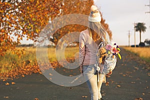 Woman walking along a country road in Autumn