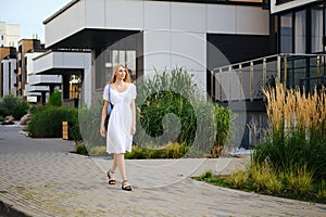 Woman walking along the pavement in modern residential area