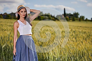 Woman is walking along the road among the fields