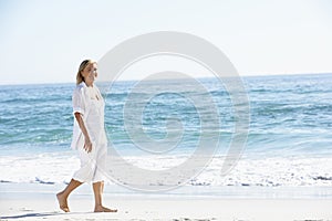 Woman Walking along Sandy Beach