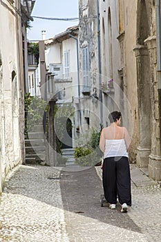 Woman walking along the street with baby carriage