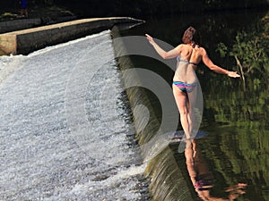 Woman walking along weir