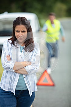 woman walking away from boyfriend and broken down vehicle