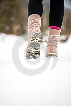 Woman walking away from the camera through winter snow