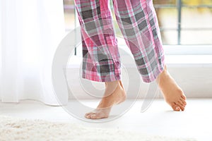 Woman walking barefoot in apartment, closeup