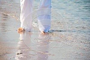 Woman walking barefoot on the beach