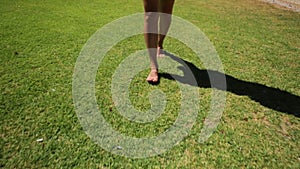 Woman walking barefoot on the grass