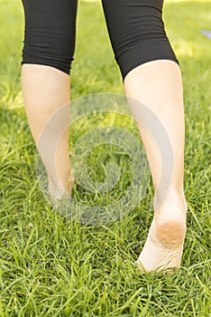 Woman walking barefoot on the grass