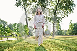 Woman walking barefoot on grass in park