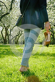woman walking barefoot on green grass