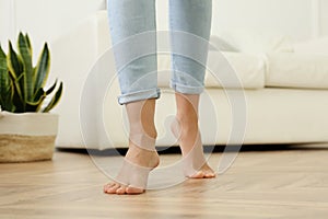 Woman walking barefoot at home, closeup. Floor heating concept