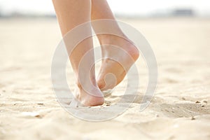 Woman walking barefoot on sand