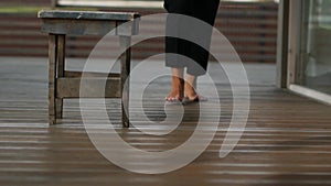 A woman walking barefoot on a wooden floor