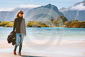 Woman walking on beach alone in Norway summer vacations trip outdoor