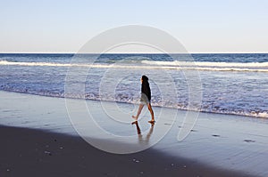 Woman walking on the beach at Crowdy National Park, NSW, Australia photo