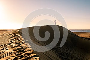 Woman walking at the beach of Maspalomas Gran Canaria Spain, girl at the sand dunes desert of Maspalomas