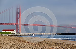 Woman walking on beach near Golden Gate Bridge