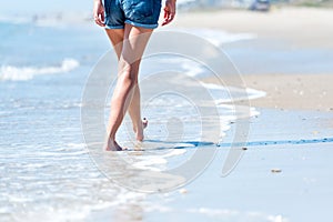 Woman walking on the beach next to ocean