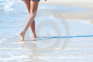 Woman walking on the beach next to ocean