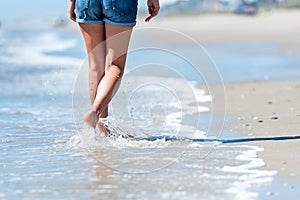 Woman walking on the beach next to ocean