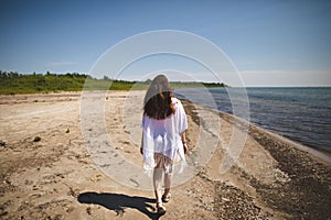 Woman walking on the beach at Presquile Provincial Park in Ontario, Canada