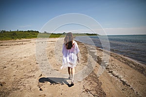 Woman walking on the beach at Presquile Provincial Park in Ontario, Canada