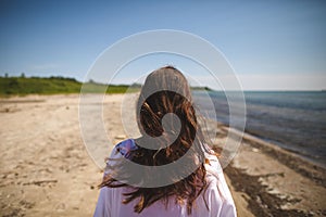 Woman walking on the beach at Presquile Provincial Park in Ontario, Canada photo