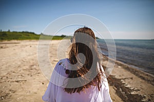 Woman walking on the beach at Presquile Provincial Park in Ontario, Canada photo