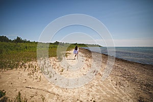 Woman walking on the beach at Presquile Provincial Park in Ontario, Canada