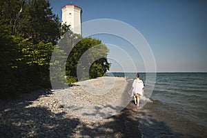 Woman walking on the beach at Presquile Provincial Park in Ontario, Canada
