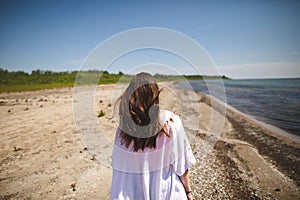 Woman walking on the beach at Presquile Provincial Park in Ontario, Canada photo