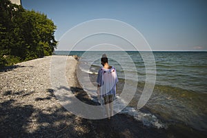 Woman walking on the beach at Presquile Provincial Park in Ontario, Canada photo