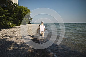 Woman walking on the beach at Presquile Provincial Park in Ontario, Canada photo