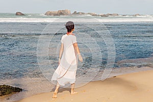 Woman walking on the beach sand