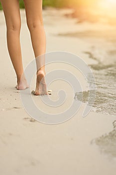 Woman walking on a beach with sunset