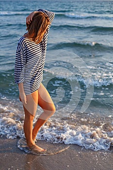 Woman walking on the beach at sunset time of relaxation