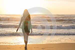 Woman walking on the beach, sunshine in the morning summer sea