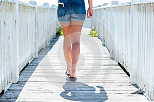 Woman walking on boardwalk out to ocean