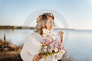 Woman walking with a bunch of flowers outdoor