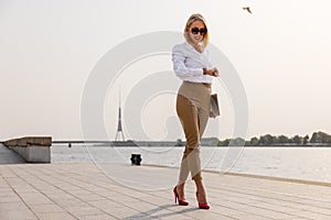 Woman walking in city and looking at watch