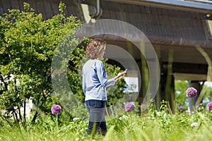 Woman walking in city park looking at her mobile phone