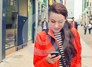 Woman walking on a city street and using her mobile phone