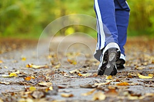 Woman walking cross country trail in autumn forest