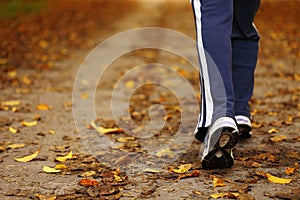 Woman walking cross country trail in autumn forest