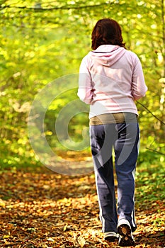 Woman walking cross country trail in autumn forest