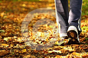 Woman walking cross country trail in autumn forest