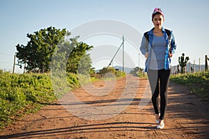 Woman walking on dirt track in countryside