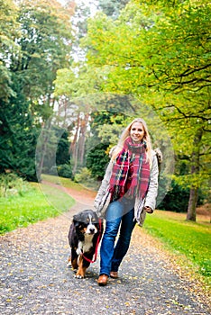 Woman walking the dog on leash in park