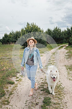 Woman walking with dog on nature out of city