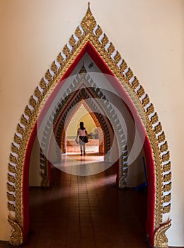 Woman walking down arched doorways in Temple